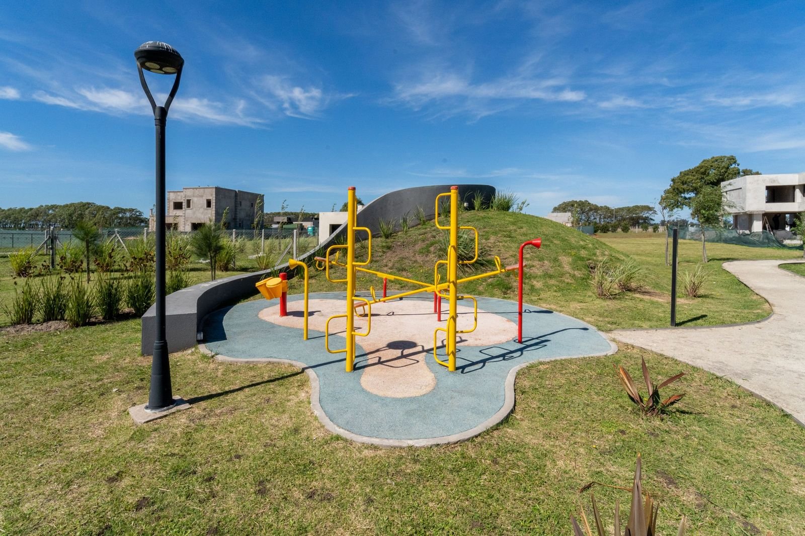 Plaza de juegos con casas en construcción de fondo